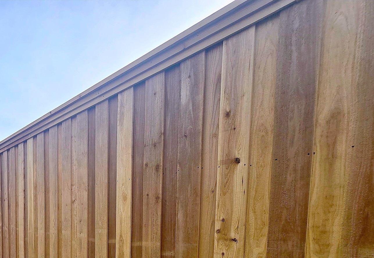 A new board on board cedar fence along a back yard